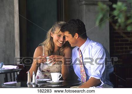 Stock Image - Young couple romancing in cafe . Fotosearch