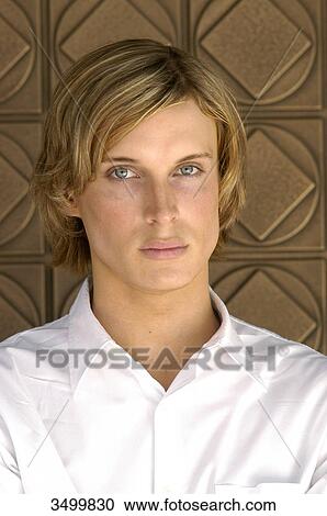 Young man in front of a wall, portrait View Large Photo Image Stock Image - Young man in front of a wall, portrait . Fotosearch