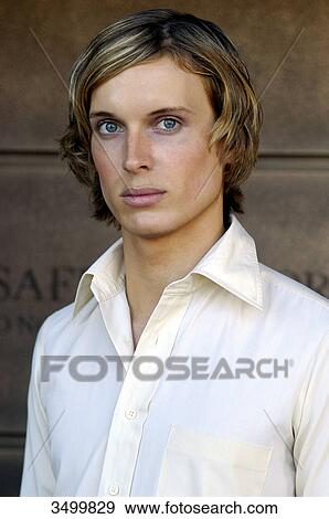 Stock Photo - Young man in front of a wall, portrait . Fotosearch