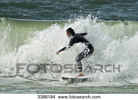 Picture - Young man surfing, Westerland, Sylt, Germany . Fotosearch