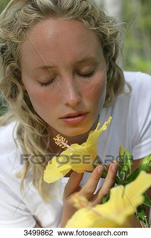 Young woman smelling a flower, portrait View Large Photo Image Stock Image - Young woman smelling a flower, portrait . Fotosearch