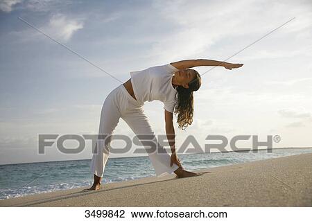 Young woman stretching at a beach, Paradise Island, Bahamas, low angle view View Large Photo Image Stock Image - Young woman stretching at a beach, Paradise Island, Bahamas, low angle view . Fotosearch