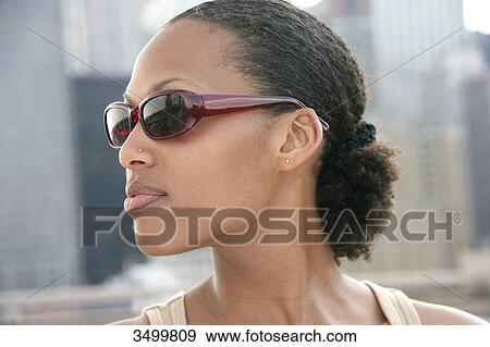 Young woman wearing sunglasses, portrait View Large Photo Image Stock Photo - Young woman wearing sunglasses, portrait . Fotosearch