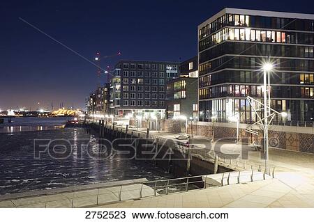 Stock Image - Buildings at waterfront lit up at night, Germany . Fotosearch