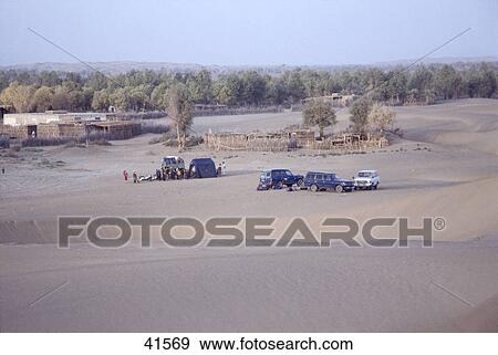 Stock Photo - Cars and jeep in desert, Taklimakan, China . Fotosearch