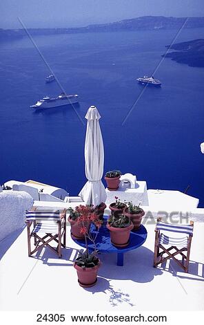 Stock Photography - Chairs with potted plants on terrace, Fira, Santorini, Cyclades Islands, Greece . Fotosearch