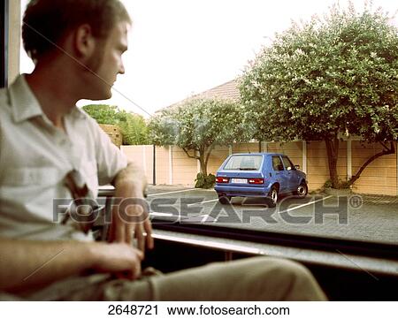 Close-up of man looking through window View Large Photo Image Stock Image - Close-up of man looking through window . Fotosearch