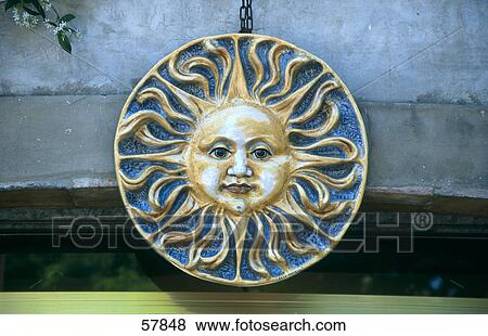 Close-up of sun face symbol hanging on wall, Italy View Large Photo Image Stock Photo - Close-up of sun face symbol hanging on wall, Italy . Fotosearch