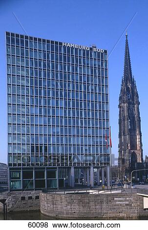 Stock Photo - Glass building and church against blue sky, St Nikolai Church, Hamburg, Germany . Fotosearch
