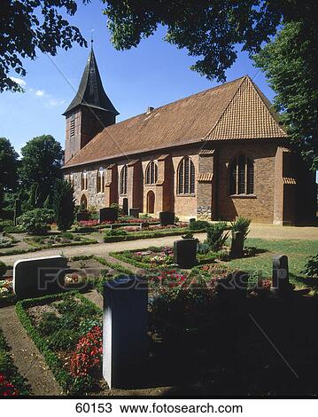Stock Image - Graves and church at cemetery, Buechen, Lauenburg, Schleswig-Holstein, Germany . Fotosearch