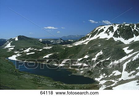 Stock Photo - Lake surrounded by snowy mountain range, USA . Fotosearch