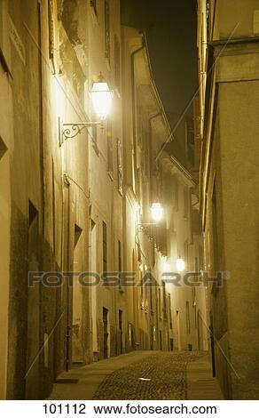 Stock Image - Lanterns lit up in street at night, Cremona, Italy . Fotosearch