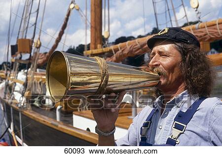 Stock Image - Man speaking on megaphone near ship at harbor, Hamburg, Germany . Fotosearch