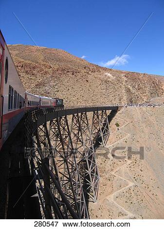 Stock Photo - Passenger train passing through railway bridge, Argentina . Fotosearch