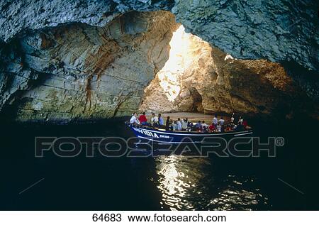 Stock Image - People on boat in grotto, Vieste, Gargano, Puglia, Italy . Fotosearch