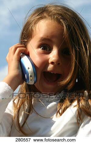 Portrait of little girl holding cellphone and looking surprised View Large Photo Image Stock Photo - Portrait of little girl holding cellphone and looking surprised . Fotosearch
