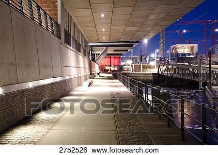Stock Photograph - Railing along path lit up at night in city, Germany . Fotosearch
