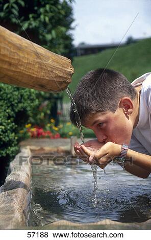 Stock Photo - Side profile of boy drinking water from well . Fotosearch