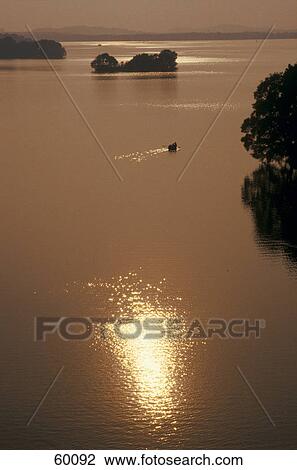 Stock Image - Silhouette of boat in the sea at dusk, Schleswig-Holstein, Germany . Fotosearch