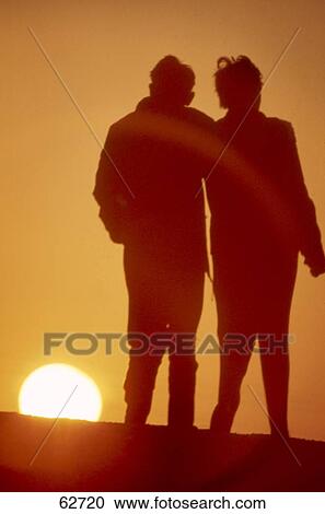 Silhouette of couple walking at dusk View Large Photo Image Stock Image - Silhouette of couple walking at dusk . Fotosearch