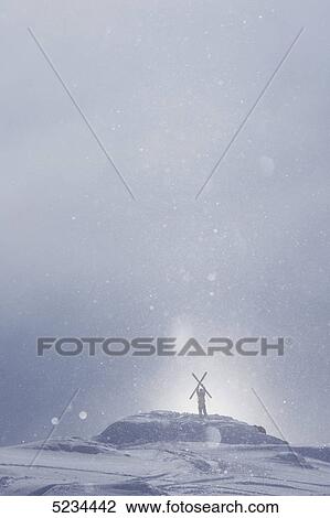 Stock Image - Skier standing on a peak . Fotosearch