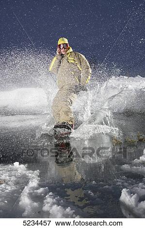 Stock Photo - Snowboarder doing a phone call . Fotosearch