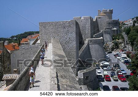 Stock Image - Tourist walking on ancient walls of city, Dubrovnik, Croatia . Fotosearch