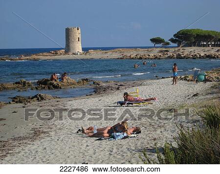 Tourists on beach with tower in background, Sarazenenturm, Sardinia, Italy View Large Photo Image Stock Photograph - Tourists on beach with tower in background, Sarazenenturm, Sardinia, Italy . Fotosearch