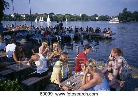 Stock Photo - Tourists relaxing at coast on footbridge, Alster Lake, Hamburg, Germany . Fotosearch