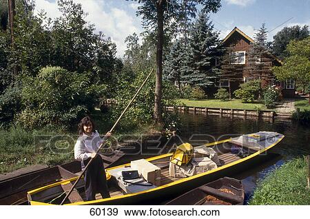 Stock Photo - Woman rowing boat in canal, Spreewald, Lehde, Brandenburg, Germany . Fotosearch