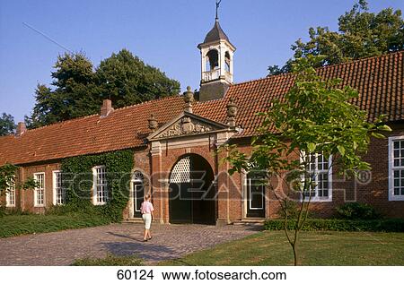 Picture - Woman walking towards castle entrance, Even burg Castle, Leer, Lower Saxony, Germany . Fotosearch