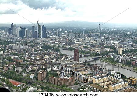 Stock Photograph - Aerial view of buildings and river in city, Main River, Frankfurt, Hessen, Germany . Fotosearch