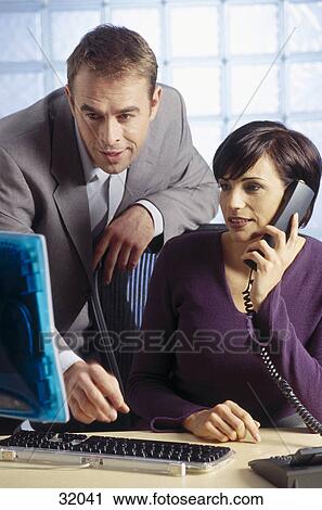 Businesspeople looking at a computer monitor View Large Photo Image Stock Image - Businesspeople looking at a computer monitor . Fotosearch