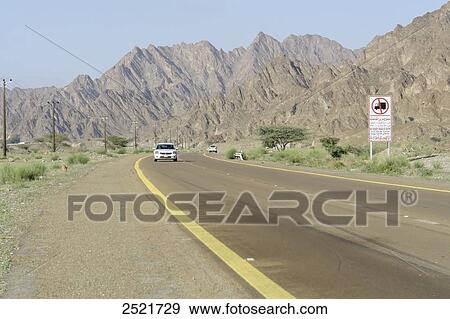 Car moving on road, Wadi Al Abadilah, Al Hajar Mountains, Fujairah, United Arab Emirates View Large Photo Image Stock Photo - Car moving on road, Wadi Al Abadilah, Al Hajar Mountains, Fujairah, United Arab Emirates . Fotosearch