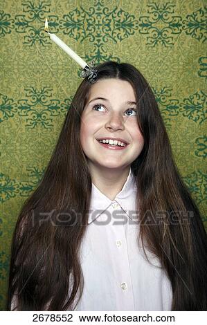 Stock Image - Close-up of girl with burning candle on her head . Fotosearch
