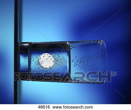 Close-up of pill dissolving in glass of water View Large Photo Image Stock Photograph - Close-up of pill dissolving in glass of water . Fotosearch