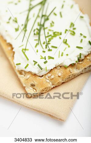 Stock Image - Crispbread with cream cheese and chive, high angle view . Fotosearch