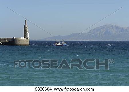 Fishing boat departing from pier in Tarifa, Spain View Large Photo Image Picture - Fishing boat departing from pier in Tarifa, Spain . Fotosearch