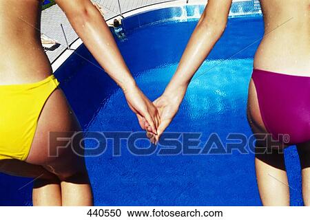 Stock Image - Girls holding hands, mid section . Fotosearch