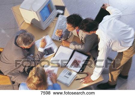 High angle view of four business executives discussing in an office View Large Photo Image Stock Photo - High angle view of four business executives discussing in an office . Fotosearch