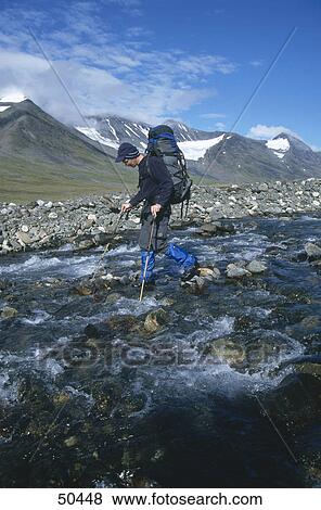 Hiker crossing stream, Scandinavia, Sweden View Large Photo Image Stock Photo - Hiker crossing stream, Scandinavia, Sweden . Fotosearch