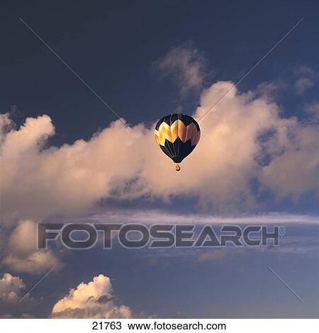 Stock Image - Hot-Air Balloon flying in sky . Fotosearch