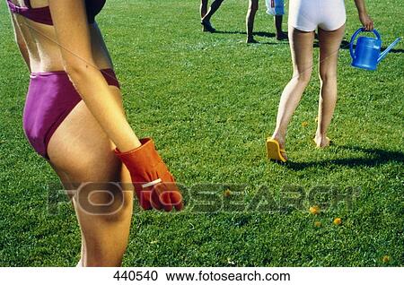 Stock Image - Low section view of women walking on grass . Fotosearch
