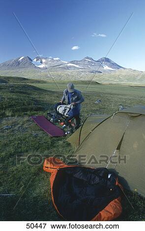 Man holding baggage in front of tent View Large Photo Image Stock Photo - Man holding baggage in front of tent . Fotosearch