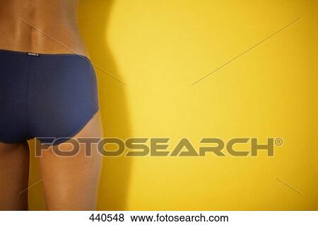 Stock Photo - Mid section view of woman leaning against wall . Fotosearch