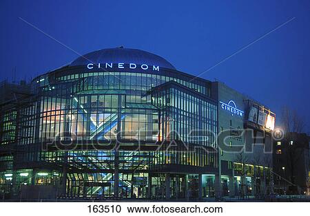 Stock Image - Movie theater lit up at dusk, Cologne, North Rhine Westphalia, Germany . Fotosearch