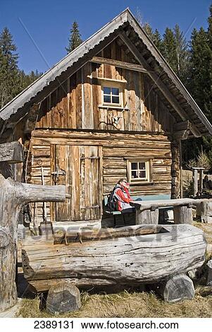 Person sitting outside of log cabin, Ramsau am Dachstein, Liezen, Styria, Austria View Large Photo Image Stock Image - Person sitting outside of log cabin, Ramsau am Dachstein, Liezen, Styria, Austria . Fotosearch