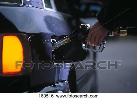 Person's hand filling car with petrol at station View Large Photo Image Stock Photograph - Person's hand filling car with petrol at station . Fotosearch