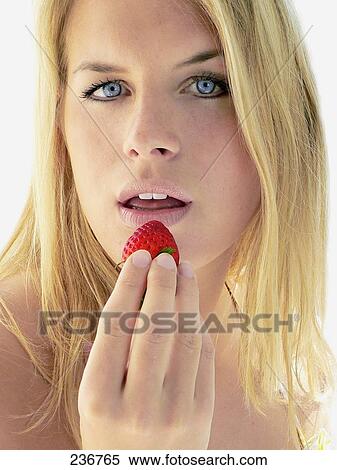 Portrait of young woman eating strawberry View Large Photo Image Stock Photography - Portrait of young woman eating strawberry . Fotosearch