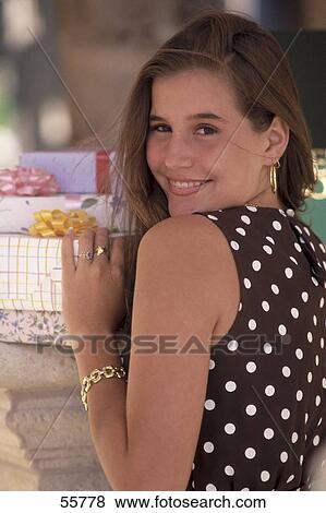 Stock Photo - Portrait of young woman smiling with gifts . Fotosearch